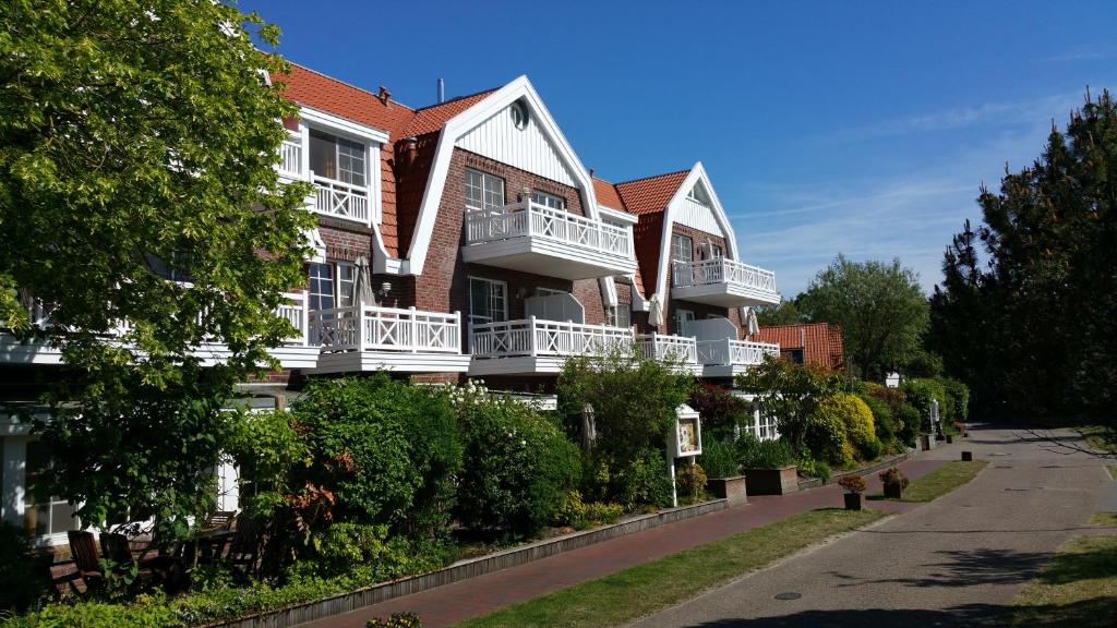 un gran edificio con balcones blancos en una calle en Spiekerooger Leidenschaft, en Spiekeroog