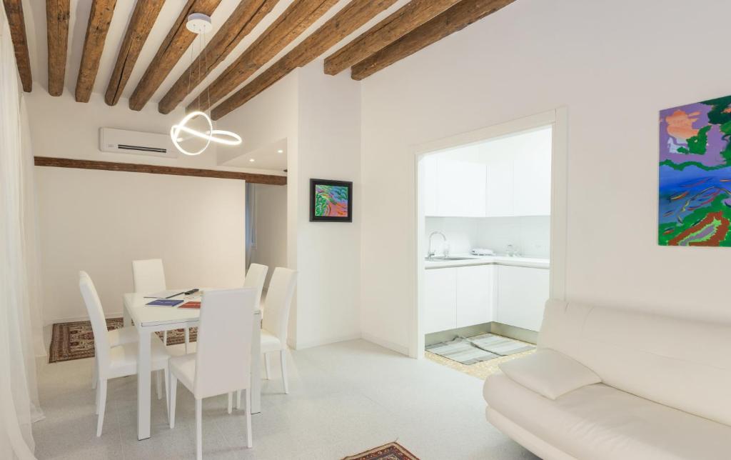 a white dining room with a table and chairs at Ca San Luca in Venice