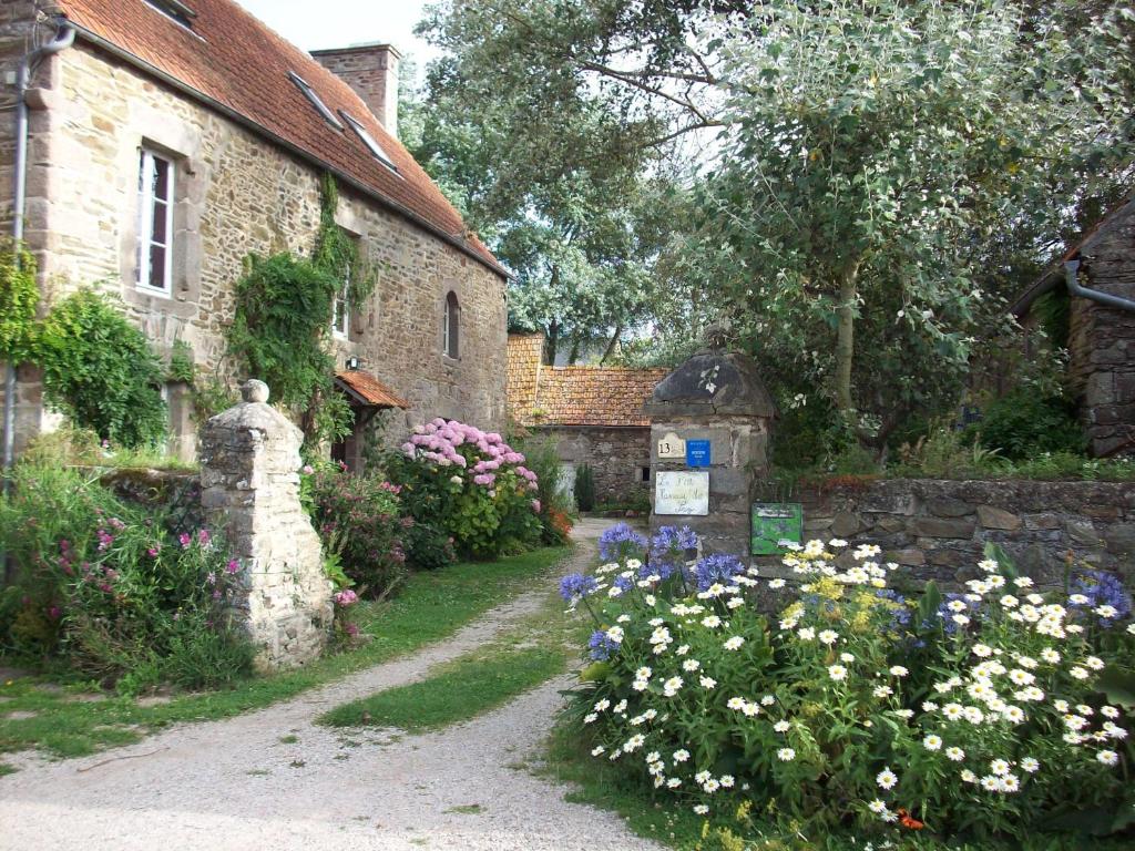 un giardino fiorito di fronte a un edificio di Le p'tit hameau de Sey a Quettehou