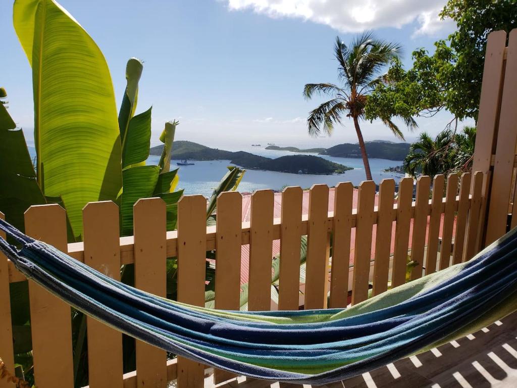 a hammock on a fence with a view of the ocean at Little Indigo Apartments in Mafolie