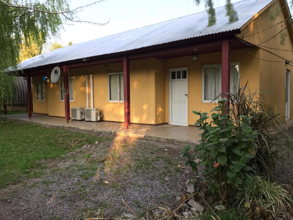 una pequeña casa amarilla con una puerta blanca en la casita de colonia 1, en Colonia del Sacramento