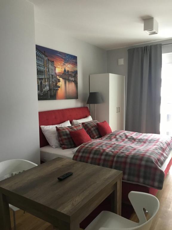 um quarto com uma cama e uma mesa em frente em Premium Apartment München Messe em Munique