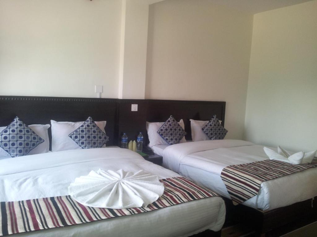 um quarto com duas camas com almofadas em Hotel Admire Pokhara Pvt. Ltd. em Pokhara