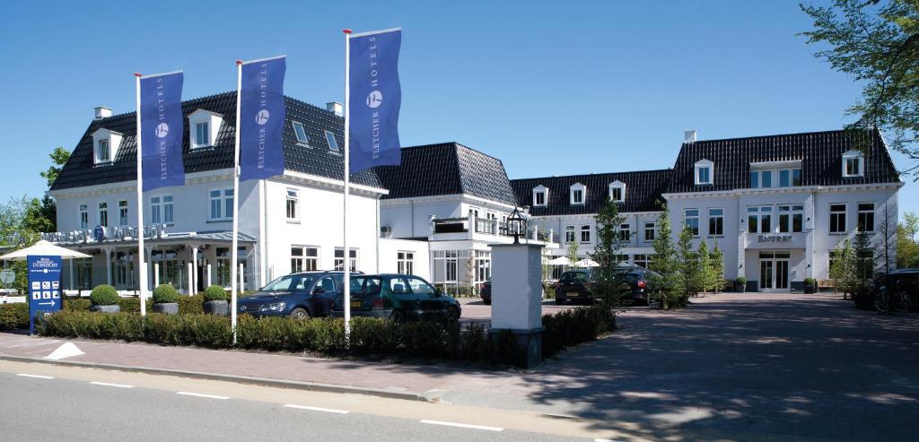 een gebouw waar een auto voor geparkeerd staat bij Fletcher Hotel-Restaurant Duinzicht in Ouddorp