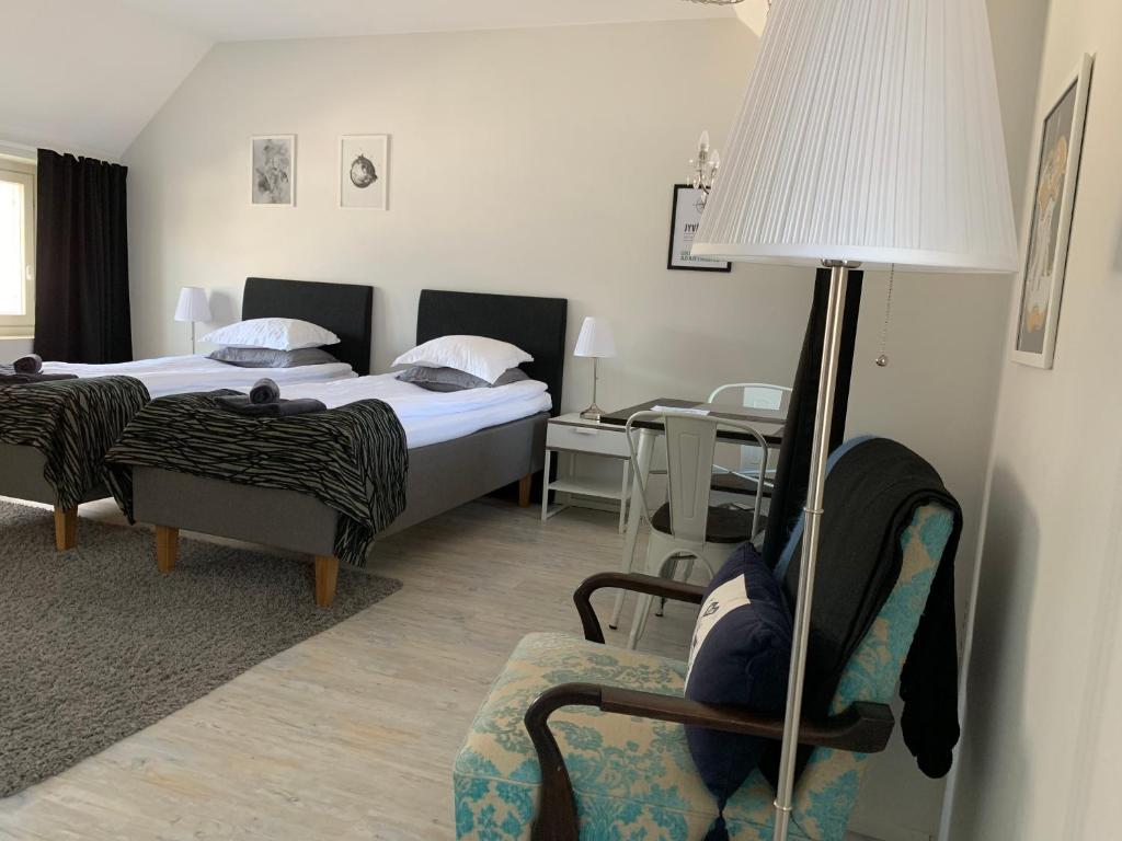 sypialnia z łóżkiem, krzesłem i lampką w obiekcie Green Door Apartments w mieście Jyväskylä