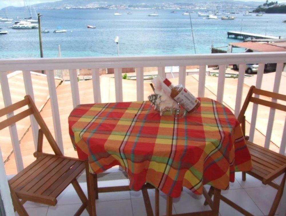 a cat sitting on top of a table on a balcony at CoCoKreyol "Antigua" in Les Trois-Îlets