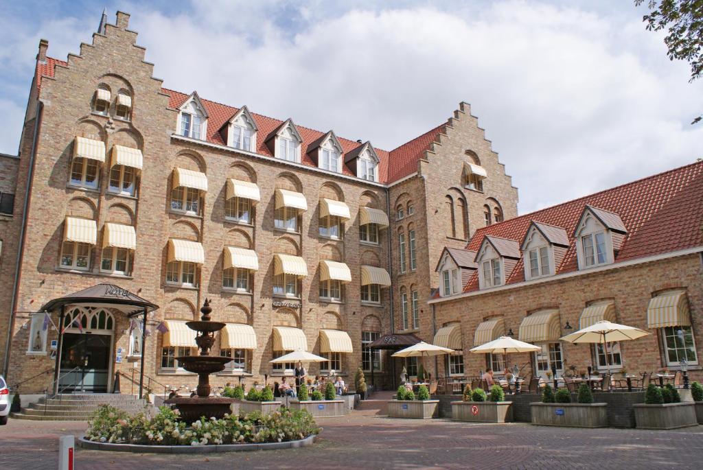 a large brick building with a fountain in front of it at Fletcher Hotel-Restaurant de Dikke van Dale in Sluis