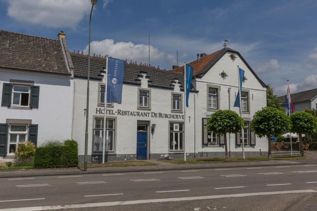 a large white building with a clock on the side of it at Fletcher Hotel Restaurant De Burghoeve in Valkenburg