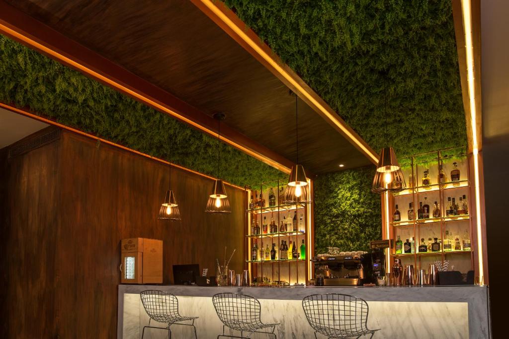 a bar with chairs and a green wall at Hub Hotel Asuncion in Asuncion