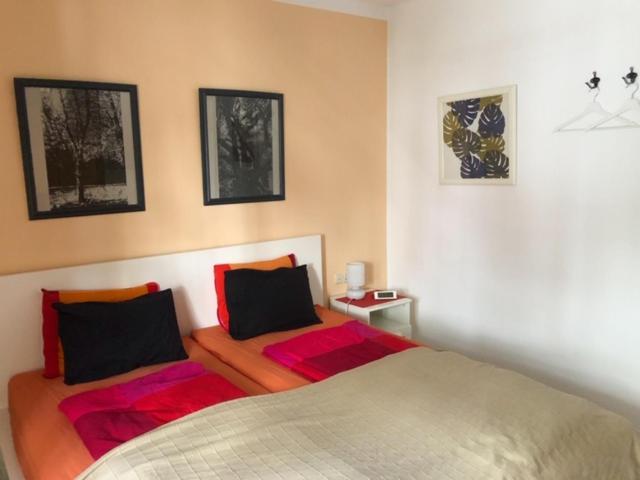 プラヤ・オンダにあるEl Descansito con Wifi gratisのベッドルーム1室(ベッド2台付)が備わります。壁に2枚の写真が飾られています。