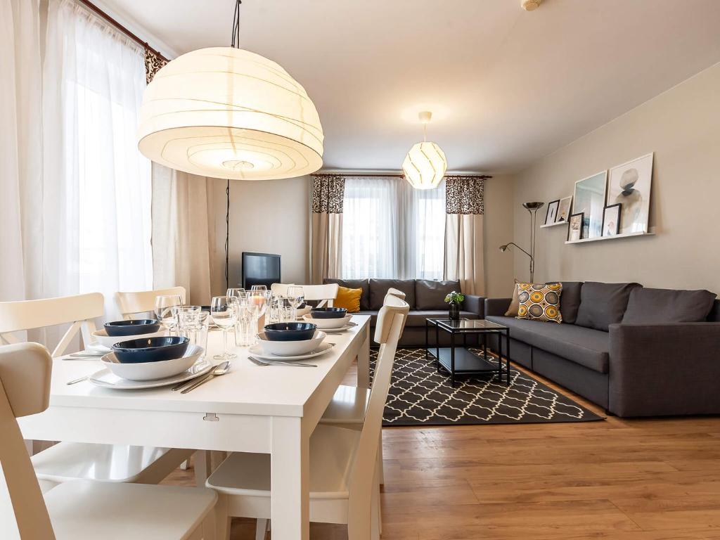 - un salon avec une table à manger blanche dans l'établissement VacationClub – Olymp Apartament 211, à Kołobrzeg