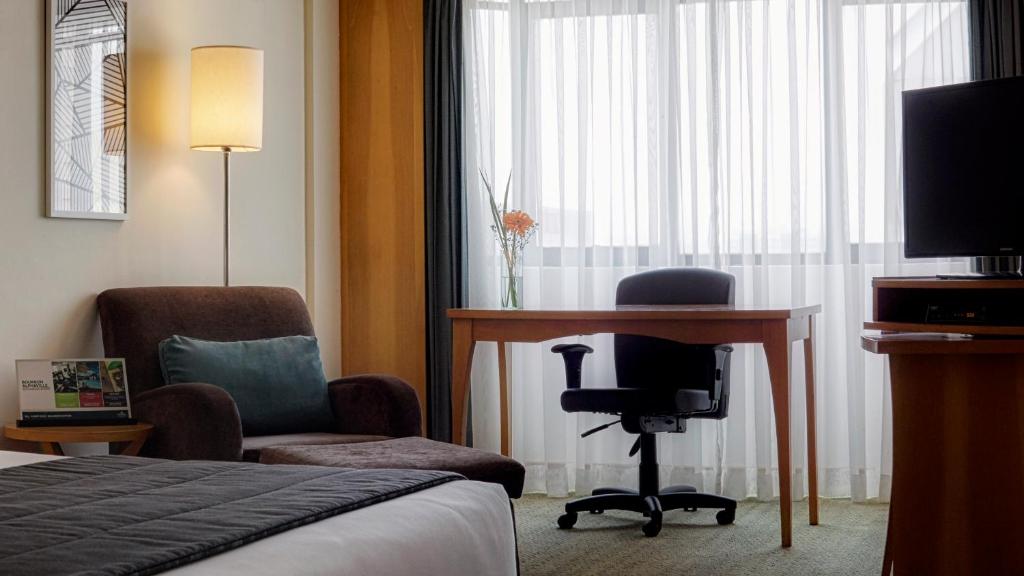 a hotel room with a desk and a chair at Sol Alphaville Hotel & Residence in Barueri