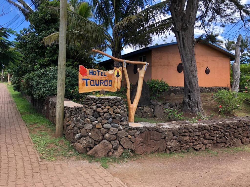 ein Schild für einen Hoteltulum vor einem Gebäude in der Unterkunft Hotel Taura'a in Hanga Roa