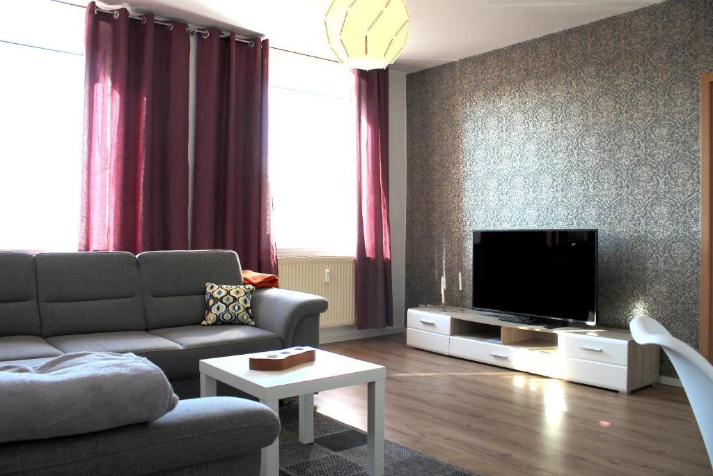 uma sala de estar com um sofá e uma televisão de ecrã plano em Cottbuser Gästewohnungen em Cottbus