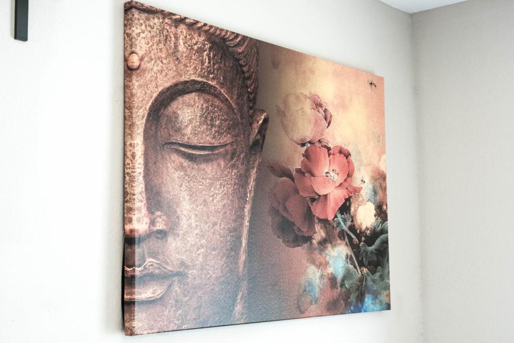 a painting of a statue on a wall with flowers at East Downtown Bungalow in Houston
