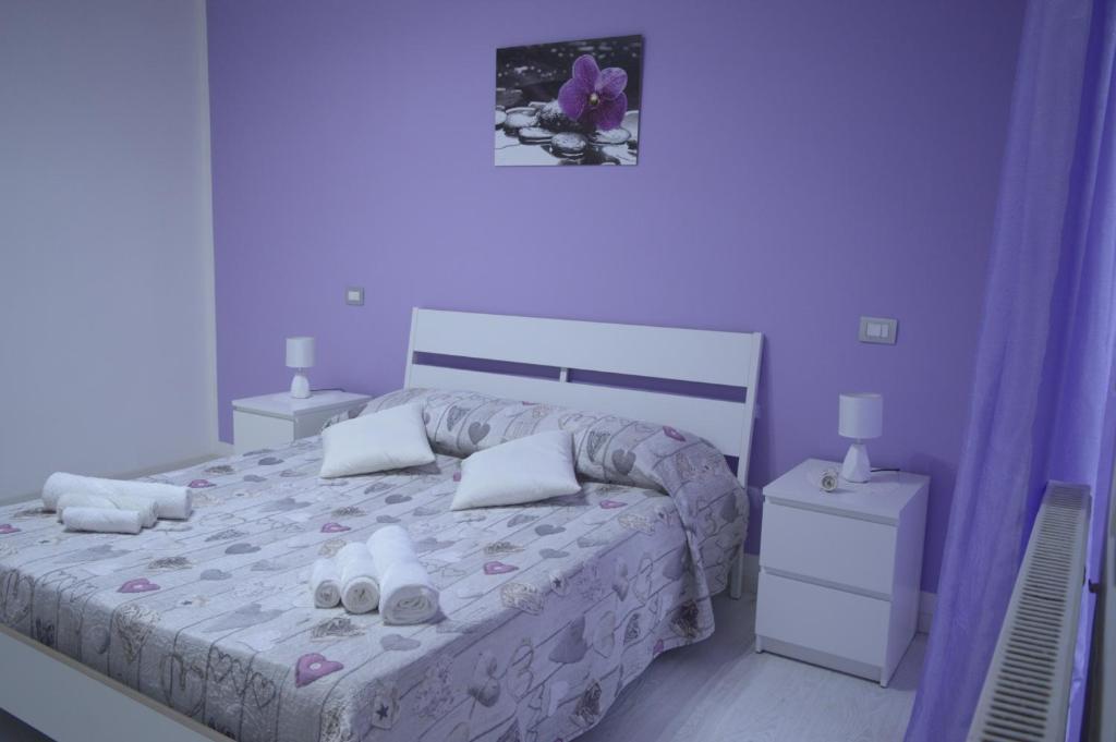 een slaapkamer met een groot bed met paarse muren bij Bellatrix in Portici