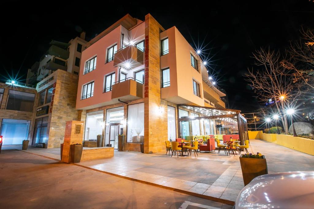 a building with tables and chairs in front of it at night at Hotel Andon Angelov in Sandanski