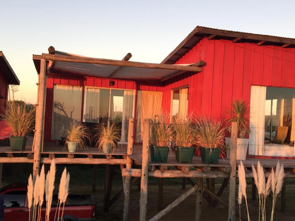 a red house with potted plants in front of it at BDL Beach Design Loft One in José Ignacio