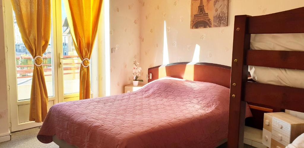 a bedroom with a bed with a red bedspread and a window at Hotel Le Saint Vorles in Châtillon-sur-Seine