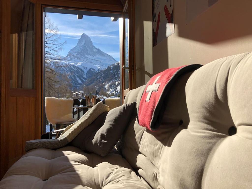 a couch in a room with a view of a mountain at Apartment with beautiful views in Zermatt in Zermatt