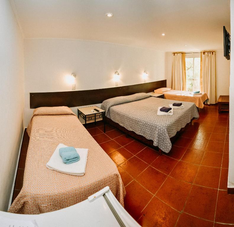 una habitación de hotel con 2 camas en una habitación en La Candida Hotel en Merlo