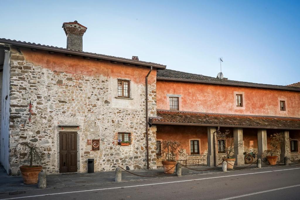een oud stenen gebouw met planten ervoor bij Locanda Osteria Marascia in Calolziocorte