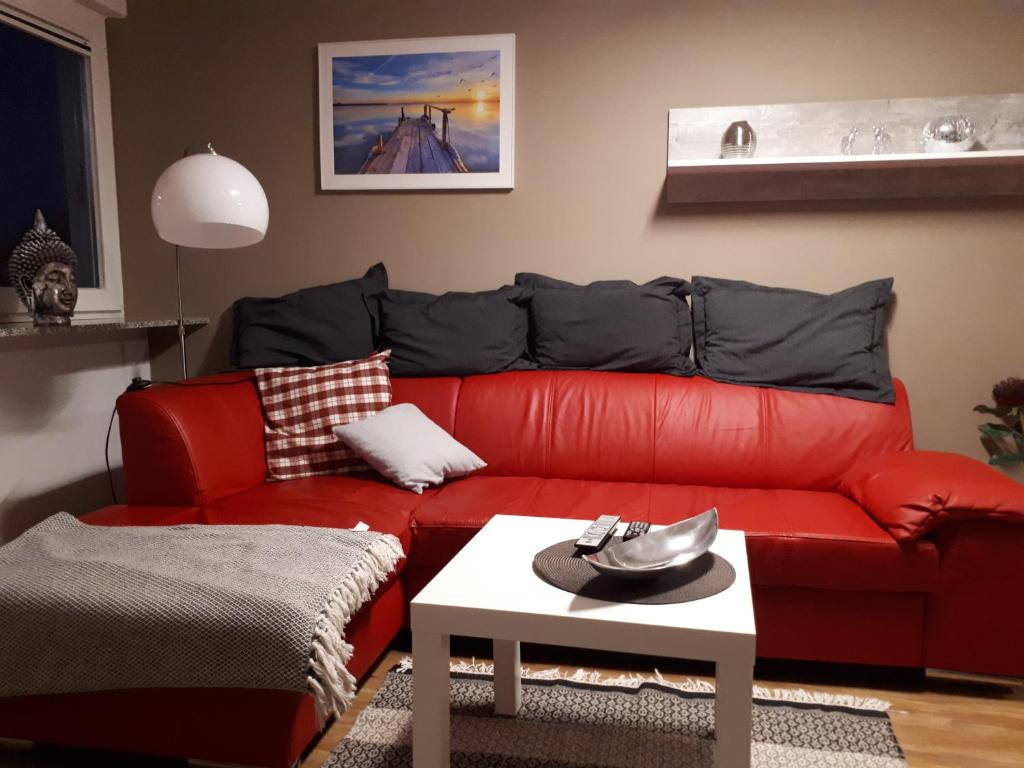 a red couch in a living room with a table at Bella Casa & Belle Maison in Saarbrücken