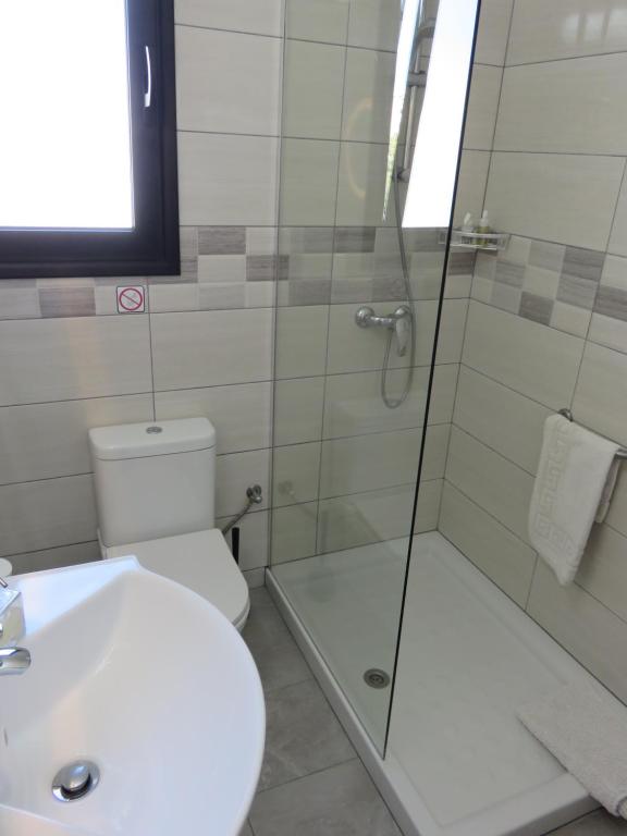 a bathroom with a shower and a toilet and a sink at Kings Avenue - Natalia's Apt in Paphos
