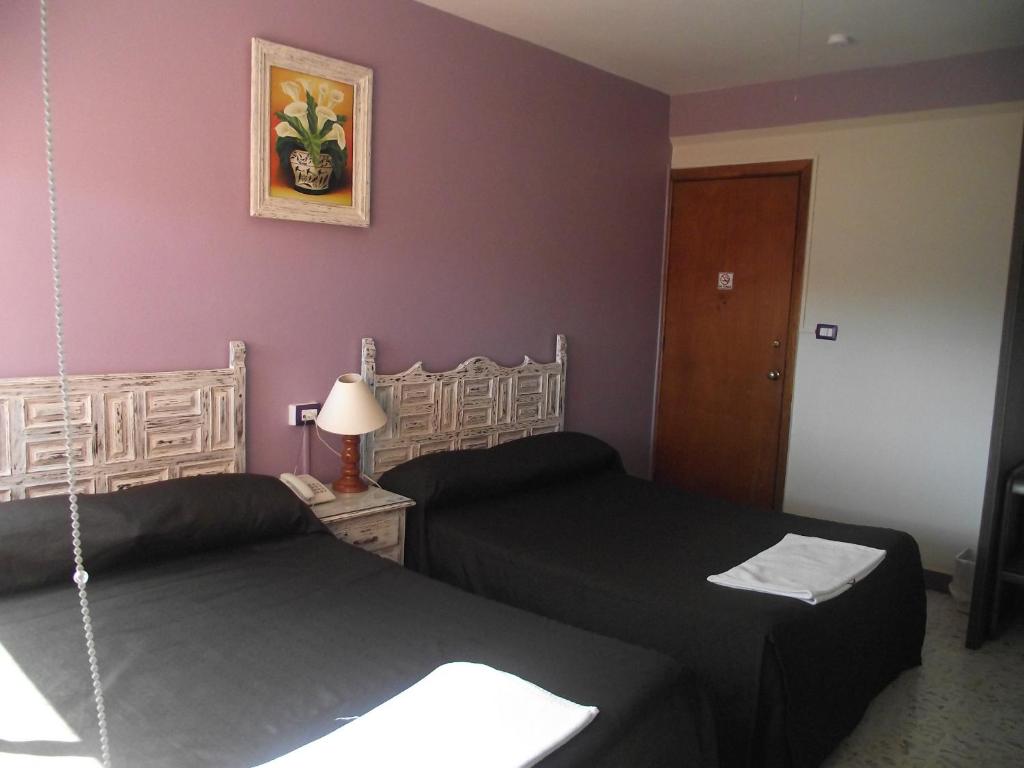 2 camas en una habitación con paredes moradas en Hotel Palacio en Xalapa