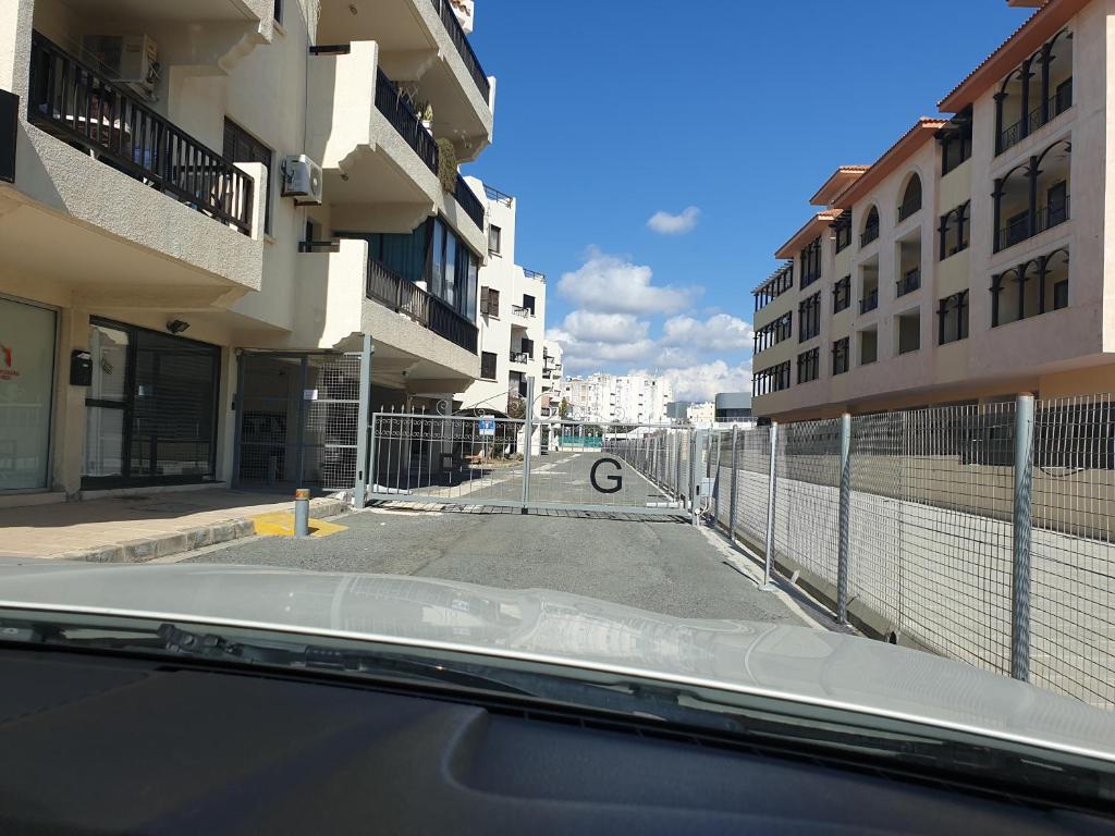 a view from a car of an empty street with buildings at Kings Avenue - Natalia's Apt in Paphos