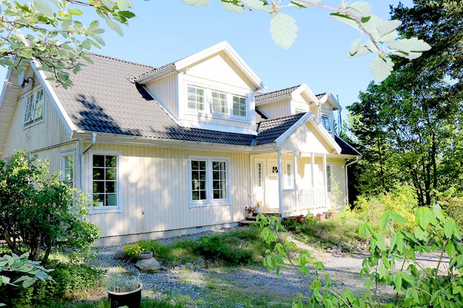 ein weißes Haus mit einem Dach in der Unterkunft Sun All Day House in Svartsjö
