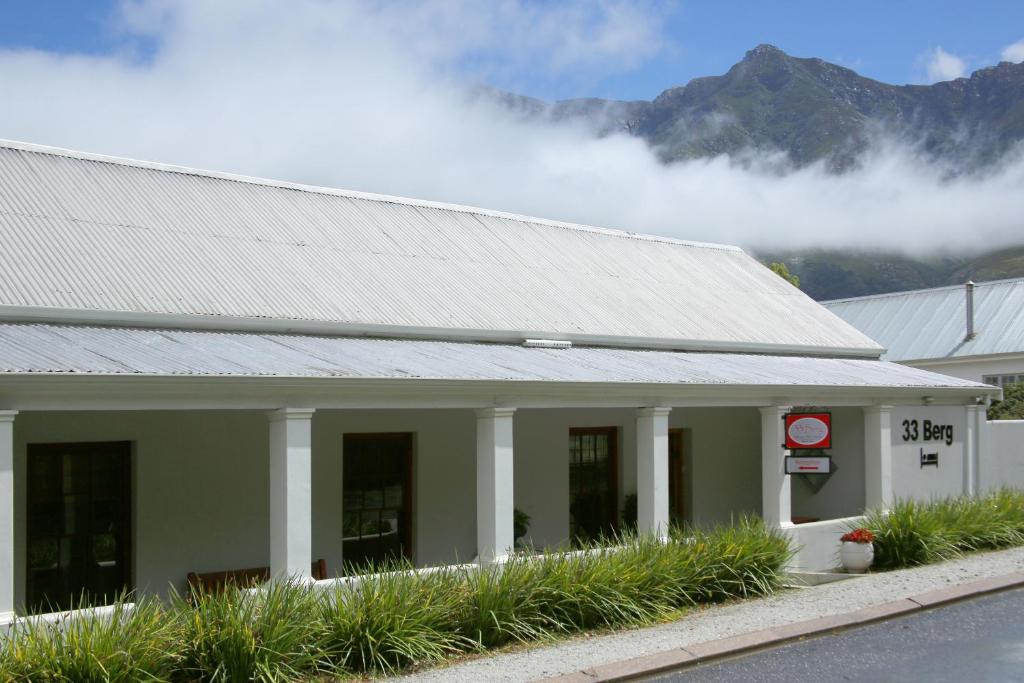 un edificio con techo gris con montañas al fondo en 33 Berg Selfcatering en Swellendam