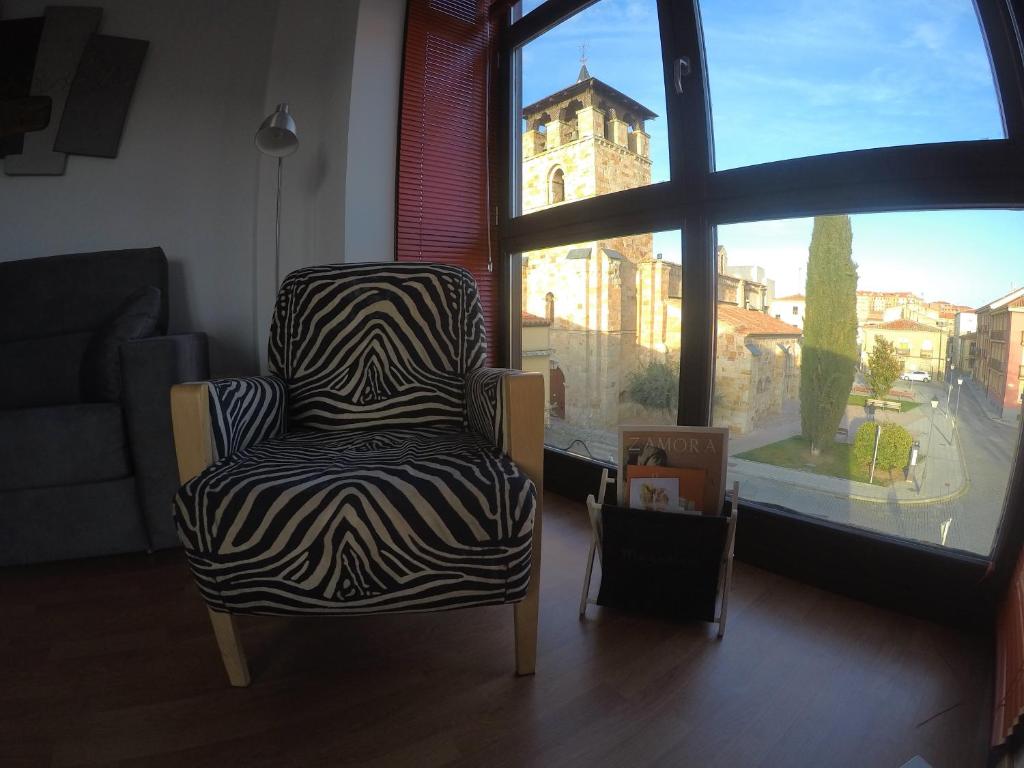 a zebra print chair in a living room with a window at enZamorarte in Zamora