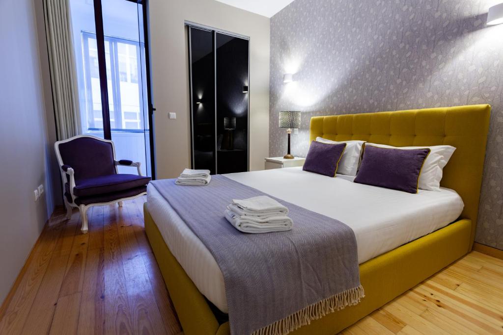 ポルトにあるOporto City View - Santo Ildefonso Luxuryのベッドルーム1室(大型ベッド1台、黄色のヘッドボード付)
