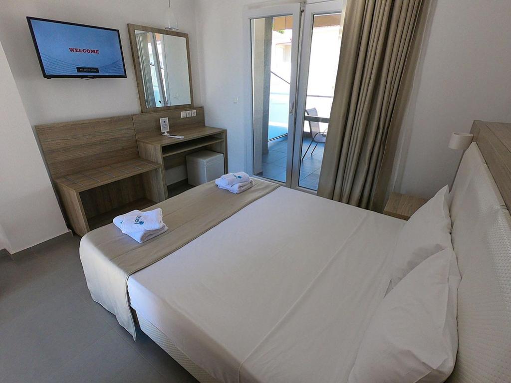 A bed or beds in a room at Finikas Garden Beach Resort Nikiti