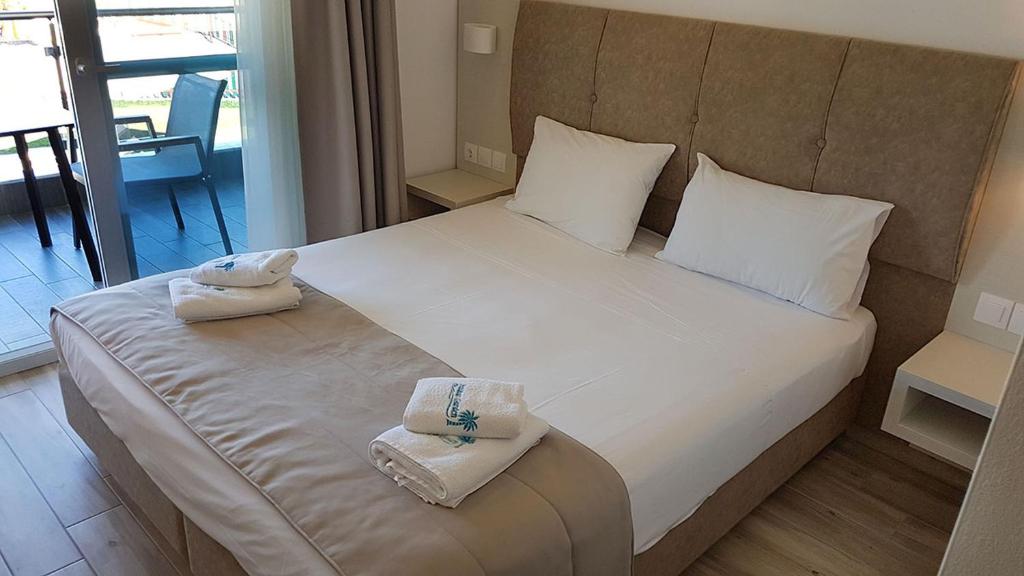 A bed or beds in a room at Finikas Garden Beach Resort Nikiti