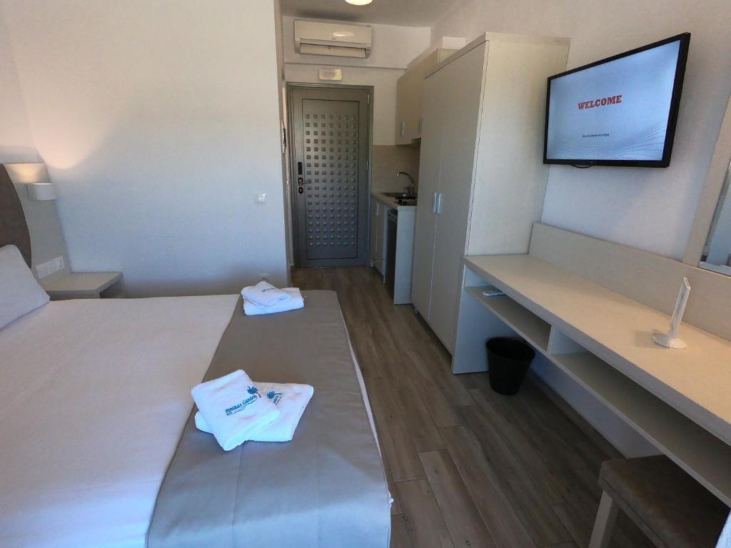 A bed or beds in a room at Finikas Garden Beach Resort Nikiti