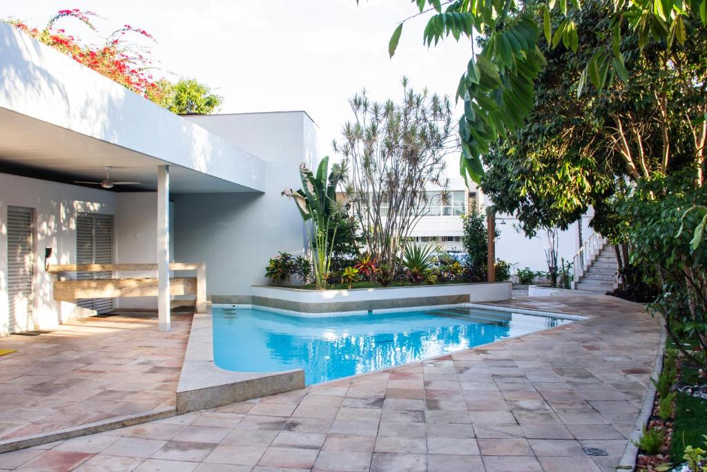 a swimming pool in a yard next to a house at Hotel das Palmeiras in Teófilo Otoni