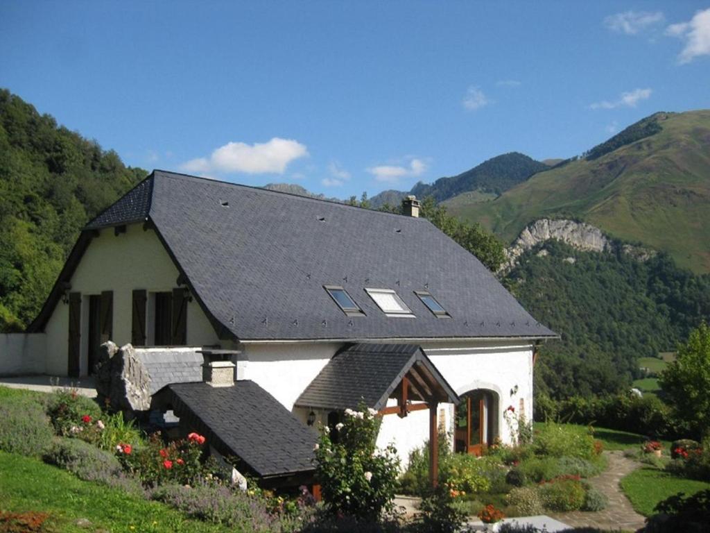 a white house with a black roof on a mountain at L'espiatet in Borce