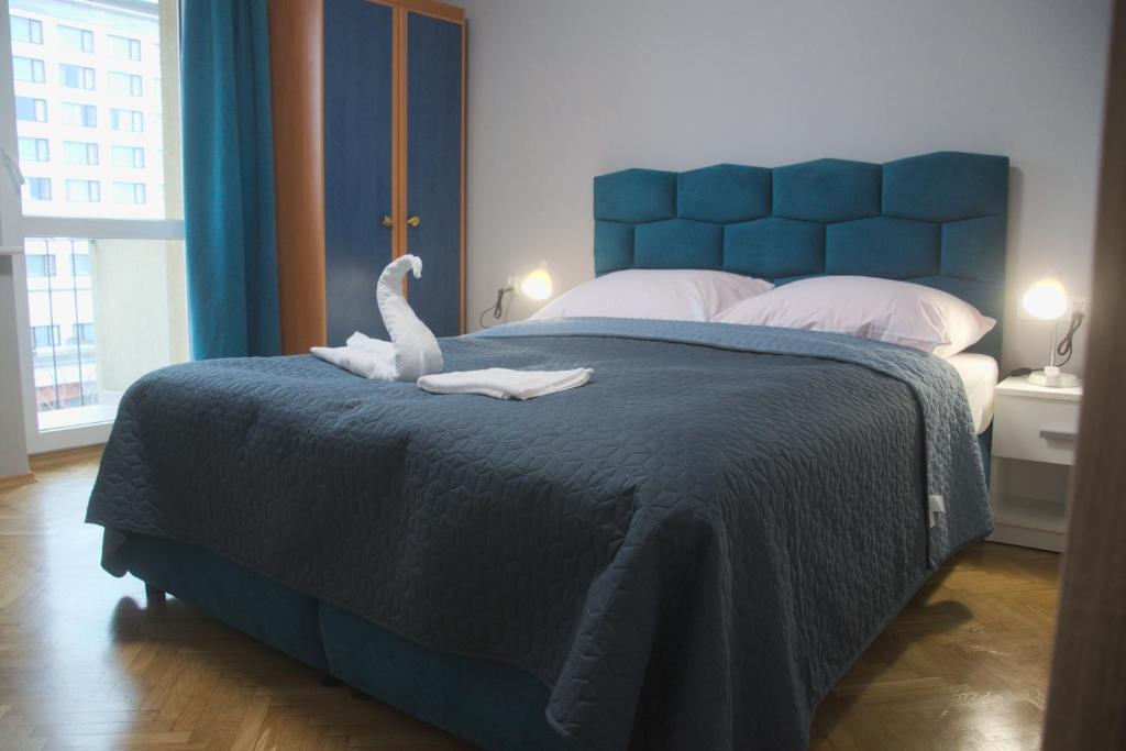 Un dormitorio con una cama azul con un cisne. en Doba Rent POKOJE CENTRUM PAŁACOWA, en Białystok