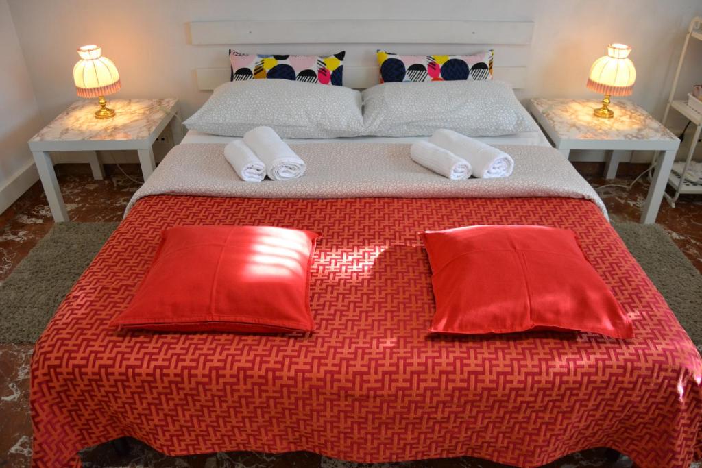 a bed with two red pillows on top of it at My Way in Pisa