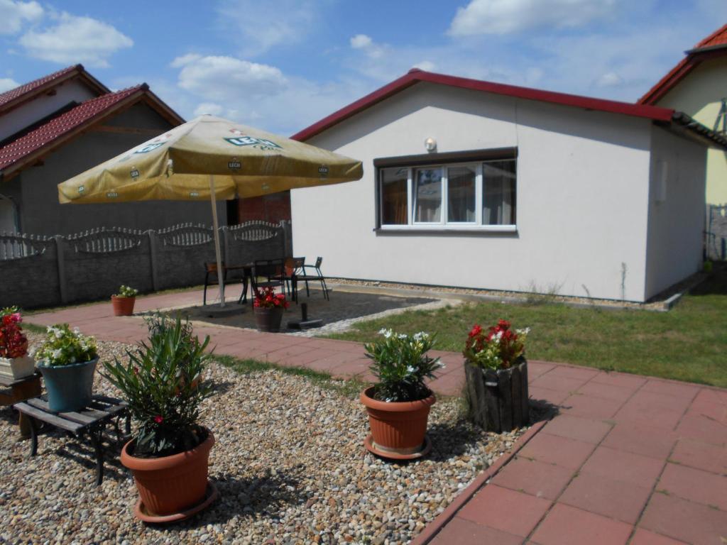 een patio met een tafel, een parasol en planten bij domek Boszkowianka Mini in Boszkowo