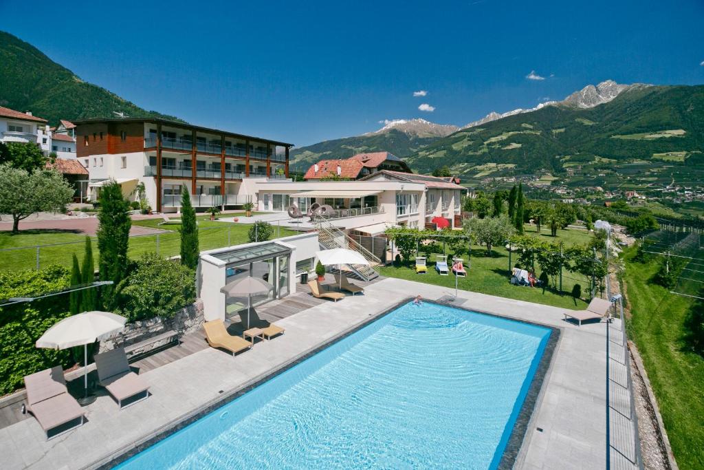 a house with a swimming pool and a resort at Appartement-Hotel Beatenhof in Tirolo