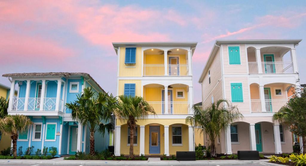 eine Reihe von Häusern mit Palmen davor in der Unterkunft Margaritaville Cottages Orlando with H2O Waterpark by Rentyl in Kissimmee