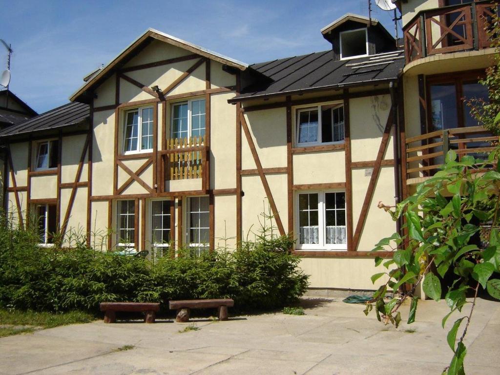 una casa con un banco delante de ella en Pokoje z Widokiem na Morze III, en Karwieńskie Błoto Pierwsze