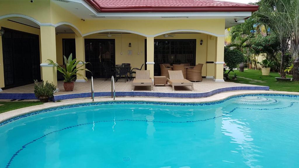 a swimming pool in front of a house at Kim Beatriz Compound in Mactan
