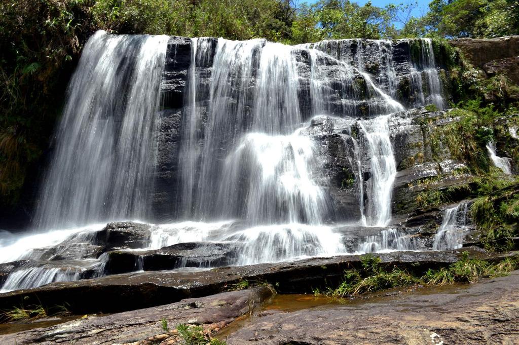 a waterfall on the side of a rock formation at Pousada Pontal do Moleque in Carrancas