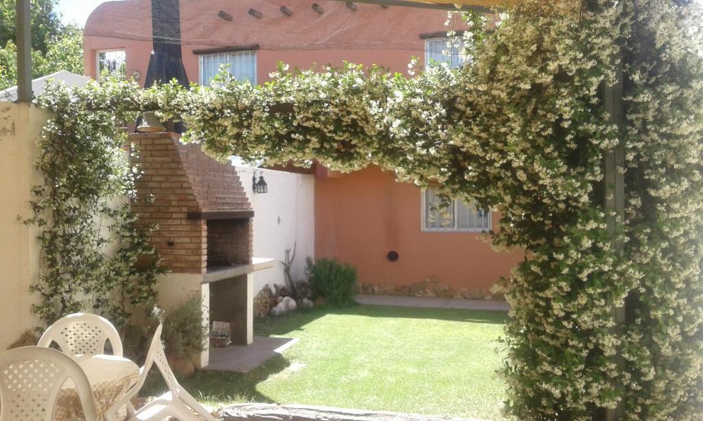 a garden with a pergola with white flowers at Las Cuatro Estaciones in San Rafael