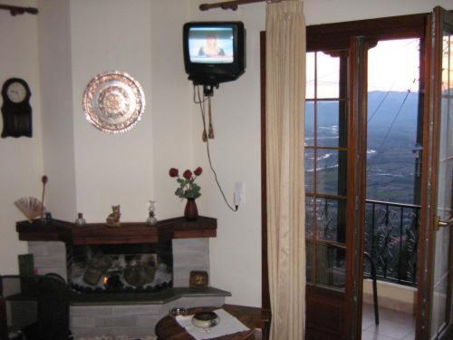 un salon avec une télévision et une cheminée dans l'établissement Gerakofolia Rooms to Let, à Konitsa