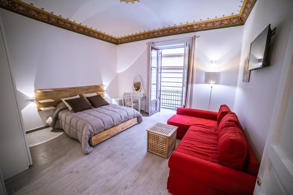 a bedroom with a bed and a red couch at B&B Opera dei Pupi in Palermo